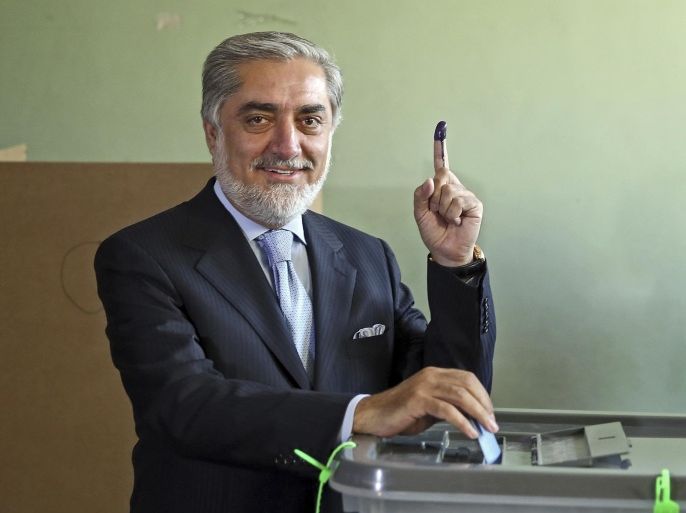 Afghanistan's presidential candidate Abdullah Abdullah poses for photos before he casts his vote at a pooling station in Kabul, Afghanistan, Saturday, June 14, 2014. Despite Taliban threats of violence, many Afghans vow to cast ballots in Saturday’s presidential runoff vote with hopes that whoever replaces Hamid Karzai will be able to provide security and stability after international forces wind down their combat mission at the end of this year. (AP Photo/Massoud Hossaini)