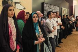 TEHRAN, IRAN - JUNE 28: Two women from the Persian Gulf region stand next to spectators during a contemporary art auction by famous Iranian artists in the dinning hall of hotel Azadi on June 28, 2013 in Tehran, Iran.