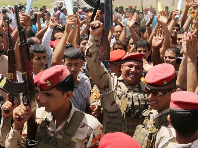 Iraqi Army soldiers and volunteers chant slogans against the al-Qaida inspired group Islamic State of Iraq and the Levant (ISIL), inside of the main army recruiting center in Baghdad, Iraq, Saturday, June. 14, 2014, after authorities urged Iraqis to help battle insurgents. Hundreds of young Iraqi men gripped by religious and nationalistic fervor streamed into volunteer centers across Baghdad Saturday, answering a call by the country's top Shiite cleric to join the fight against Sunni militants advancing in the north. (AP Photo/Karim Kadim)