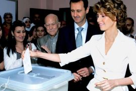 In this photo released by the Syrian official news agency SANA, Syrian first lady Asma Assad, right, casts her vote as Syrian President Bashar Assad, stands next to her at a polling station, in Damascus, Syria, Tuesday, June 3, 2014. Thousands of Syrians lined up outside polling centers in government-controlled areas around the country to vote Tuesday in the presidential election that Assad is widely expected to win but which has been denounced by critics as a sham. (AP Photo/SANA)