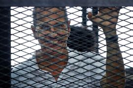 Al-Jazeera journalist Peter Greste looks out from the defendant's cage during the sentencing hearing for journalists working for Al-Jazeera in a courtroom in Cairo, Egypt, Monday, June 23, 2014. An Egyptian court on Monday convicted three journalists from Al-Jazeera English and sentenced them to seven years in prison each on terrorism-related charges, bringing widespread criticism that the verdict was a blow to freedom of expression. The three, Australian Peter Greste, Canadian-Egyptian Mohamed Fahmy and Egyptian Baher Mohammed, have been detained since December charged with supporting the Muslim Brotherhood, which has been declared a terrorist organization, and of fabricating footage to undermine Egypt's national security and make it appear the country was facing civil war. (AP Photo/Ahmed Abd El Latif, El Shorouk Newspaper) EGYPT OUT