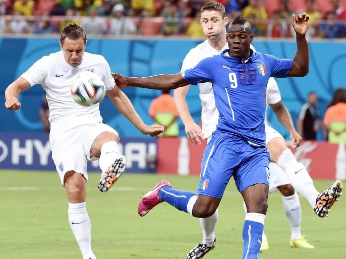 Italy's forward Mario Balotelli (R) struggles for the ball with England's defender Phil Jagielka during the FIFA World Cup 2014 group D preliminary round match between England and Italy at the Arena Amazonia in Manaus, Brazil, 14 June 2014. (RESTRICTIONS APPLY: Editorial Use Only, not used in association with any commercial entity - Images must not be used in any form of alert service or push service of any kind including via mobile alert services, downloads to mobile devices or MMS messaging - Images must appear as still images and must not emulate match action video footage - No alteration is made to, and no text or image is superimposed over, any published image which: (a) intentionally obscures or removes a sponsor identification image; or (b) adds or overlays the commercial identification of any third party which is not officially associated with the FIFA World Cup) EPA/DANIEL DAL ZENNARO
