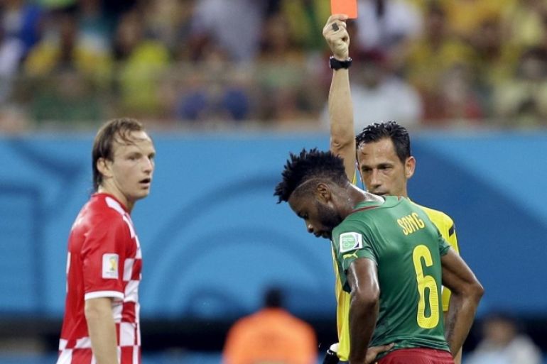 Referee Pedro Proenca from Portugal gives a red card to Cameroon's Alex Song as Croatia's Ivan Rakitic looks on during the group A World Cup soccer match between Cameroon and Croatia at the Arena da Amazonia in Manaus, Brazil, Wednesday, June 18, 2014. (AP Photo/Themba Hadebe)