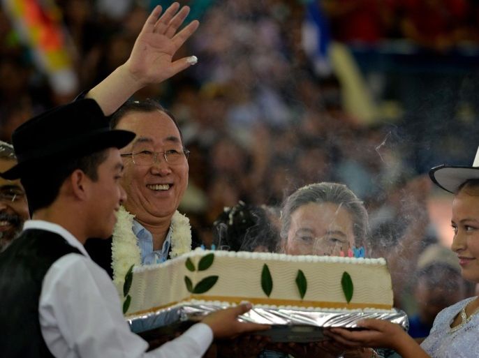UN Secretary General Ban Ki-moon (L), accompanied by his wife Yoo Soon-taek (C), waves at the public after blowing 70 candles on a birthday cake, allegedly prepared using Coca flour, a common ingredient used in the Andean highlands, during a celebration in his honour with the attendance of Bolivian President Evo Morales (not in picture), and thousands of attendants congregated at the coliseum in Torno in a rural area 37 km west of Santa Cruz, Bolivia on June 13, 2014. Ban is in Bolivia for the opening of the G77 + China tomorrow that will last three days, with the attendance of representatives from 134 countries. AFP PHOTO/CRIS BOURONCLE