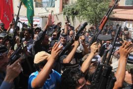 Iraqi Shiite tribal fighters raise their weapons and chant slogans against the al-Qaida inspired Islamic State of Iraq and the Levant (ISIL) in Baghdad's Sadr city, Iraq, Saturday, June 14, 2014. Thousands of Shiites from Baghdad and across southern Iraq answered an urgent call to arms Saturday, joining security forces to fight the Islamic militants who have captured large swaths of territory north of the capital and now imperil a city with a much-revered religious shrine. (AP Photo/Karim Kadim)