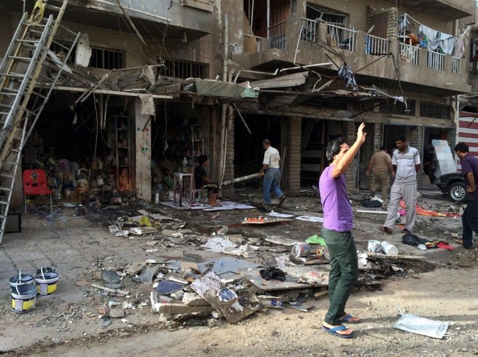 Iraqis inspect the site of a car bomb attack that targeted the area a day earlier in Baghdad, Iraq, 08 June 2014. At least 60 people were killed in a wave of car bombings that rocked Baghdad a day earlier. The six bombings occurred in mostly Shiite areas in eastern, northern, southern and central parts of the Iraqi capital, police said.