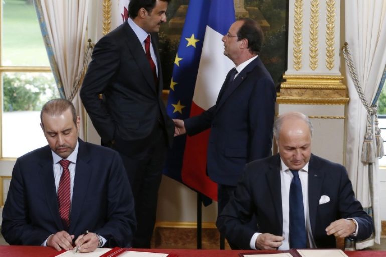 Emir of Qatar, Sheikh Tamim bin Hamad Al Thani, back left, and French President Francois Hollande, back right, speak as they attend a signature of agreements ceremony with French Foreign Affairs Minister Laurent Fabius, right, and Qatar's Minister of Commerce Sheik Ahmad Bin Jassem bin Mohammed Al Thani, left, at the Elysee Palace in Paris, Monday, June 23, 2014. French President Francois Hollande hosts the Emir of Qatar, Sheikh Tamim bin Hamad Al Thani, and signs a raft of business deals. The leaders are expected to discuss violence in Iraq and Syria, where France and Qatar have supported the opposition to Syrian President Bashar Assad. (AP Photo/Ian Langsdon, Pool)