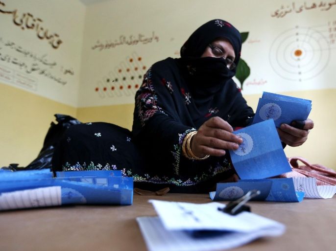 An Afghan election worker counts ballots at a polling station in Jalalabad, east of Kabul, Afghanistan, Saturday, June 14, 2014. Afghans brave threats of violence and searing heat to vote in a presidential runoff that will mark the country's first peaceful transfer of authority, an important step toward democracy as foreign combat troops leave. (AP Photo/Rahmat Gul)