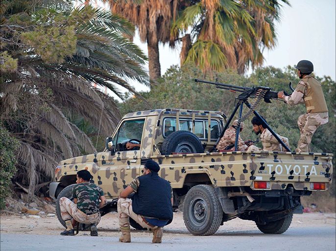 Irregular forces loyal to former army general Khalifa Haftar stand by an armed vehicle during clashes with Islamist militants in the eastern city of Benghazi June 2, 2014. Eight people were killed and 15 wounded when fighting broke out on Monday between the Libyan army and Islamist militants in the eastern city of Benghazi, medical sources said. The Ansar al-Sharia militant group attacked a camp on Monday belonging to army special forces, residents there said. Forces of the renegade general fighting Islamists later joined the battle, using combat helicopters, they added. REUTERS
