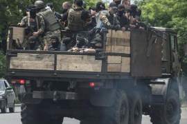 Ukrainian troops stand atop of a vehicle as they leave a site of battle in Mariupol, eastern Ukraine, Friday, June 13, 2014. Ukraine’s interior minister says that government troops have attacked pro-Russian separatists in the southern port of Mariupol. Arsen Avakov said Friday that four government troops were wounded as forces retook buildings occupied by the rebels in the center of the town. (AP Photo/Evgeniy Maloletka)