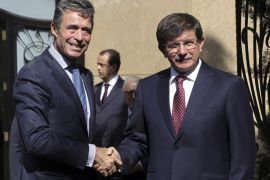 Turkey's Foreign Minister Ahmet Davutoglu, right, and NATO's Secretary-General Anders Fogh Rasmussen shake hands as they pose for cameras before a meeting in Ankara, Turkey, Monday, June 16, 2014. (AP Photo/Burhan Ozbilici)