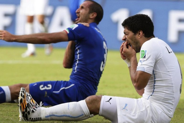 Italy's Giorgio Chiellini (L) claims he was bitten by Uruguay's Luis Suarez (R) during the FIFA World Cup 2014 group D preliminary round match between Italy and Uruguay at the Estadio Arena das Dunas in Natal, Brazil, 24 June 2014. (RESTRICTIONS APPLY: Editorial Use Only, not used in association with any commercial entity - Images must not be used in any form of alert service or push service of any kind including via mobile alert services, downloads to mobile devices or MMS messaging - Images must appear as still images and must not emulate match action video footage - No alteration is made to, and no text or image is superimposed over, any published image which: (a) intentionally obscures or removes a sponsor identification image; or (b) adds or overlays the commercial identification of any third party which is not officially associated with the FIFA World Cup) EPA/EMILIO LAVANDEIRA JR
