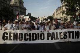 People march on the streets, displaying a banner reading 'Palestine genocide' and Palestinian flags, as they shout anti Israeli slogans, during a protest against the Israeli airstrikes of the Gaza strip, in Madrid, Spain, Thursday, July 17, 2014. About 2,000 people took part in the demonstration. (AP Photo/Daniel Ochoa de Olza)