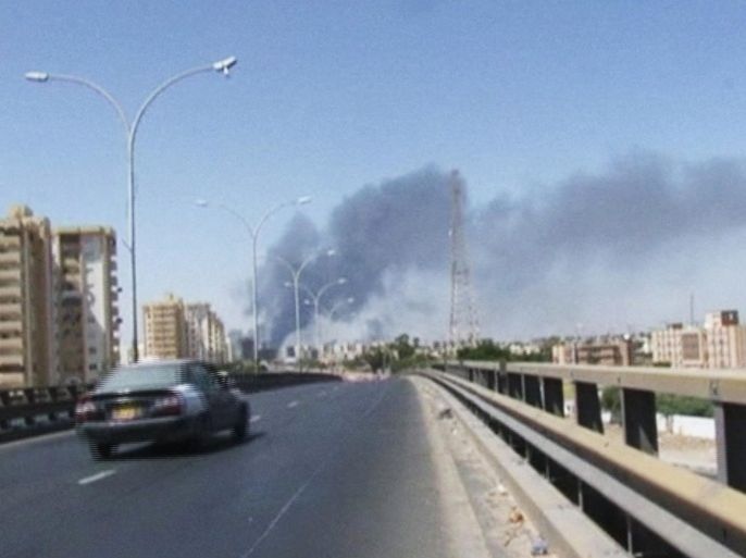 In this image made from video by The Associated Press, smoke rises from the direction of Tripoli airport in Tripoli, Libya, Sunday, July 13, 2014. Rival militias battled Sunday for the control of the international airport in Libya's capital, as gunfire and explosions echoed through the city and airlines canceled some international flights. (AP Photo)