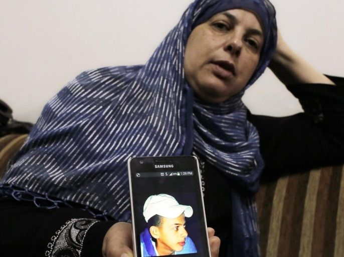 Suha, mother of Mohammed Abu Khudair, shows a picture of her son on her mobile phone at their home in Shuafat, an Arab suburb of Jerusalem July 2, 2014. The body of an abducted Palestinian youth was found in Jerusalem on Wednesday, raising suspicions he had been killed by Israelis avenging the deaths of three abducted Jewish teens. News of the discovery of 16-year-old Mohammed Abu Khudair, who was last seen being bundled into a van earlier in the day, triggered clashes between rock-throwing Palestinians and Israeli police in the city. Police said they had found a body in the wooded outskirts of Jerusalem. Abu Khudair's father told Reuters the force had told him the body was his son. REUTERS/Ammar Awad (JERUSALEM - Tags: POLITICS CIVIL UNREST TPX IMAGES OF THE DAY)