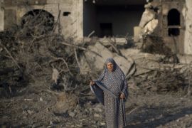 A Palestinian woman gestures as she stands amidst destruction following an Israeli military strike in Gaza City on July 08, 2014 . The Israeli air force launched dozens of raids on the Gaza Strip overnight after massive rocket fire from the enclave pounded southern Israel, leaving 17 people injured, sources said. AFP PHOTO / MAHMUD HAMS