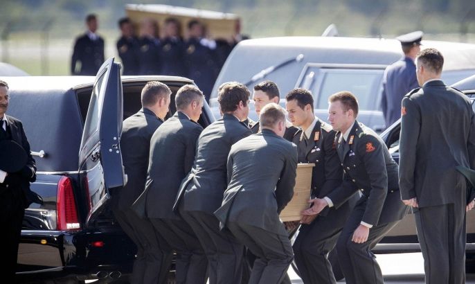 Pallbearers place a coffin into a hearse during a ceremony to mark the return of the first bodies, of passengers and crew killed in the downing of Malaysia Airlines Flight 17, from Ukraine at Eindhoven military air base, Netherlands, Wednesday, July 23, 2014. After being removed from the planes, the bodies are to be taken in a convoy of hearses to a military barracks in the central city of Hilversum, where forensic experts will begin the painstaking task of identifying the bodies and returning them to their loved ones. (AP Photo/Phil Nijhuis)