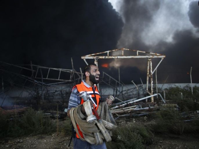 A Palestinian firefighter reacts as he tries to put out a fire at Gaza's main power plant, which witnesses said was hit in Israeli shelling, in the central Gaza Strip July 29, 2014. Israeli tank fire hit the fuel depot of the Gaza Strip's only power plant on Tuesday, witnesses said, cutting electricity to Gaza City and many other parts of the Palestinian enclave of 1.8 million people.An Israeli military spokeswoman had no immediate comment and said she was checking the report. Israel launched its Gaza offensive on July 8, saying its aim was to halt rocket attacks by Hamas and its allies. REUTERS/Mohammed Salem (GAZA - Tags: POLITICS CIVIL UNREST ENERGY TPX IMAGES OF THE DAY)