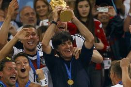 Germany's coach Joachim Loew lifts the World Cup trophy after his team won the 2014 World Cup final against Argentina at the Maracana stadium in Rio de Janeiro July 13, 2014. REUTERS/Kai Pfaffenbach (BRAZIL - Tags: SPORT SOCCER WORLD CUP)