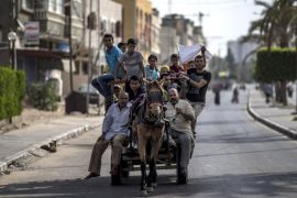 A horse drawn cart carrying Palestinians displaced from the northern Beit Hanun district in the Gaza Strip make their way towards a UN school in Beit Lahia where residents have fled after fleeing heavy fighting in their area on July 21, 2014. The UN Security Council called for an 'immediate ceasefire' as Israel pressed on with a blistering assault on Gaza taking the Palestinian death toll above 500. AFP PHOTO/MARCO LONGARI