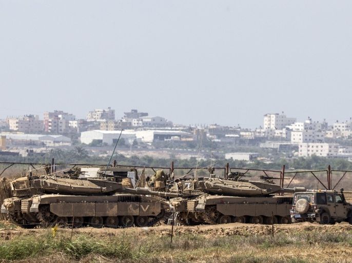 Israeli soldiers sit atop their tanks on the Israeli side of the border with the Gaza Strip, on July 3, 2014. Israeli warplanes pounded Gaza and militants hit back with 15 rockets, further hiking tension after a day of violence triggered by the suspected revenge killing of a Palestinian teenager. AFP PHOTO / JACK GUEZ
