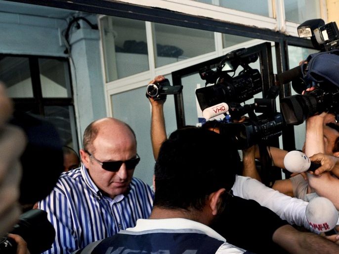 Members of the media gather around former head of the anti-terror department of the Istanbul police, Ali Fuat Yilmazer (L), detained as part of a criminal probe over alleged corruption, as he leaves a hospital in Istanbul after a medical check-up at the start of his custody in Istanbul on July 22, 2014. Turkish authorities on July 22 arrested dozens of senior police officers in a criminal probe over alleged illegal wire-tapping and forgery, the latest crackdown on opponents of Prime Minister Recep Tayyip Erdogan ahead of presidential polls. A total of 67 serving and former top police officers were arrested, prosecutors said in a statement. Most of the arrests were in Istanbul but raids were also carried out in the capital Ankara and cities including Izmir and Diyarbakir. AFP PHOTO / OZAN KOSE