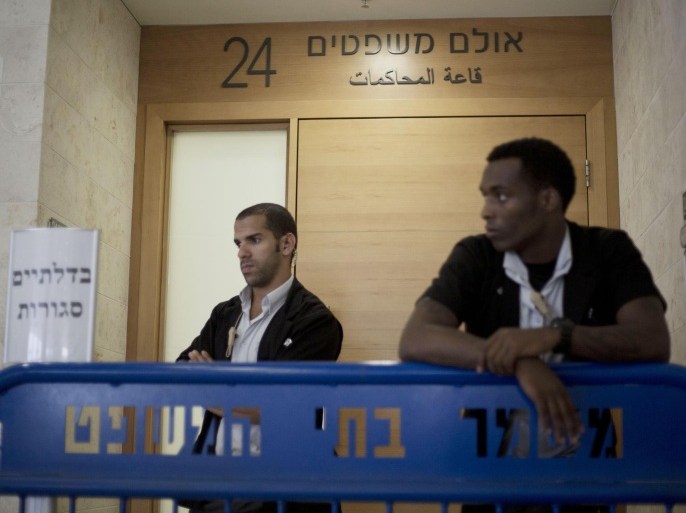 Israeli court security officers stand guard at the entrance to a courtroom in Petah Tikva, Israel, Sunday, July 6, 2014. Israeli authorities on Sunday announced the arrests of several Jewish suspects in the death of Muhammed Abu Khdeir, 16, a Palestinian teenager who was abducted and killed last week, marking a major breakthrough in a case that has sparked violent protests in Arab areas of Jerusalem and northern Israel. In a joint statement, Israeli police and the Shin Bet security agency said the suspects were arrested early Sunday. They remained in custody and were being interrogated by the Shin Bet. (AP Photo/Ariel Schalit)