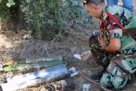 A Lebanese army expert dismantles two rockets that were found ready to fire into northern Israel, in the southern Lebanese village of Al-Mari, Lebanon, Friday, July. 11, 2014. The Lebanese army said in a statement that an "unknown side" fired three rockets Friday morning from the Marjayoun-Hasbaya region toward Israel. (AP Photo/Lotfallah Daher)