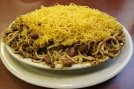 This photo made Friday, May 16, 2014, in Cincinnati, shows a plate of Cincinnati chili. Cincinnati is known for it's quirky version of chili, a pile of sweet, cinnamon-flavored meat sauce served over a plate of spaghetti noodles and topped with a heaping mound of shredded cheddar. (AP Photo/Al Behrman)