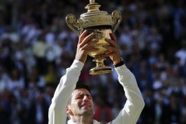 Novak Djokovic of Serbia holds up the trophy after defeating Roger Federer of Switzerland in the men's singles final at the All England Lawn Tennis Championships in Wimbledon, London, Sunday July 6, 2014. (AP Photo/Ben Curtis)
