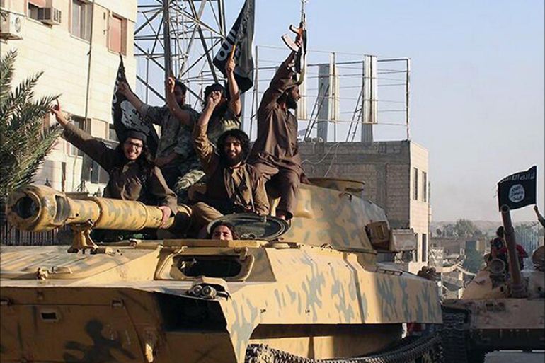 مقاتلون من تنظيم الدولة الإسلامية في العراق والشام في شوارع الرقة شمال سوريا بعد سيطرتهم على أسلحة الجيش العراقي - أسوشيتدبرس - مجلة الجزيرة