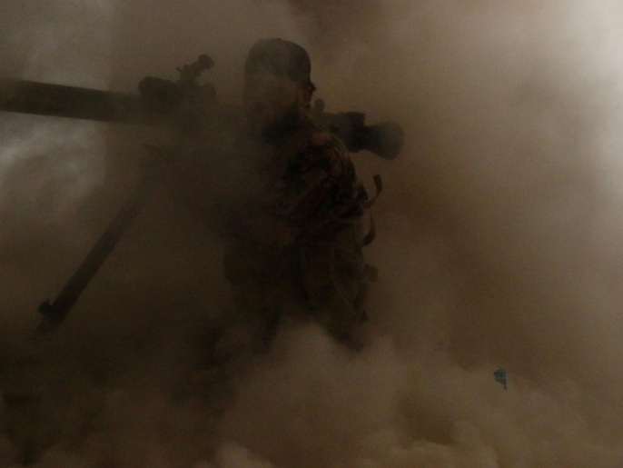 مقاتل من المعارضة المسلحة وسط غبار المعارك في مدينة مورك بريف حماة (رويترز)
