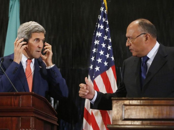 U.S. Secretary of State John Kerry (L) looks at Egypt's Foreign Minister Sameh Shukri during a news conference at a hotel in Cairo July 25, 2014. Kerry said on Friday that there were still disagreements on the terminology for a Gaza truce and called for a seven-day humanitarian ceasefire for the Muslim Eid al-Fitr holiday next week. REUTERS/Pool (EGYPT - Tags: POLITICS CONFLICT CIVIL UNREST)