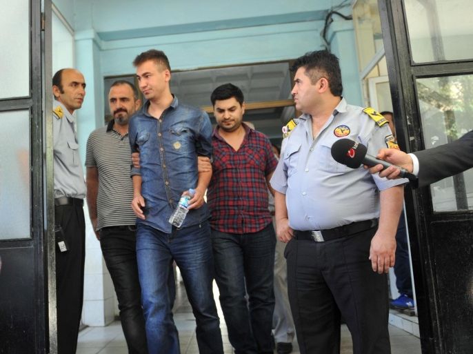 An unidenfied police officer (C), detained as part of a criminal probe over alleged corruption, arrives at a hospital for a medical check-up at the start of his custody in Istanbul on July 22 ,2014. The Turkish authorities on July 22 arrested 55 senior police officers in a criminal probe over alleged corruption and abuse of office, the latest apparent crackdown on opponents of Prime Minister Recep Tayyip Erdogan ahead of presidential polls, television reports said. AFP PHOTO / OZAN KOSE