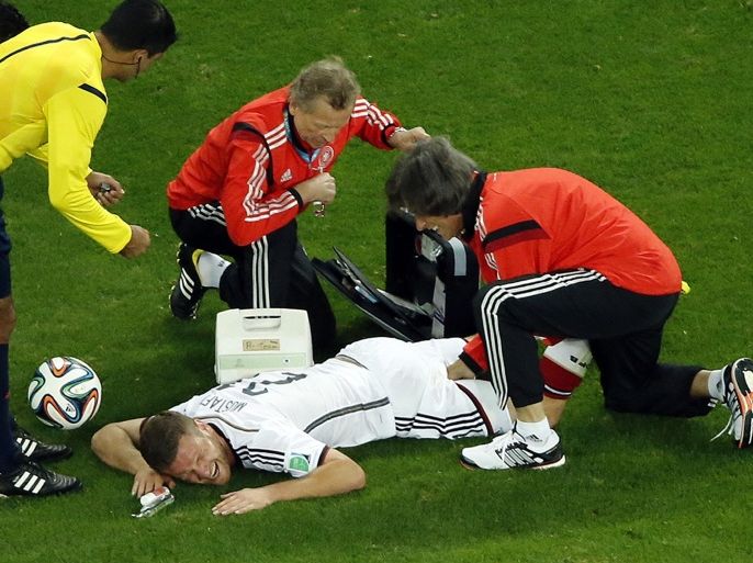 Germany's Shkodran Mustafi, bottom, gets treatment after suffering an injury during the World Cup round of 16 soccer match between Germany and Algeria at the Estadio Beira-Rio in Porto Alegre, Brazil, Monday, June 30, 2014. (AP Photo/Fabrizio Bensch, pool)
