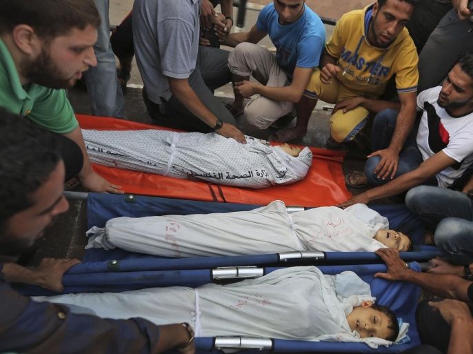 Palestinian mourners gather around the bodies of Jihad Esam Shahebar, 10, Fullah Tariq Shahebar, 8, and Wasim Esam Shahebar, 9, during their funeral in Gaza City, Thursday, July 17, 2014. The children were killed by an Israeli missile strike at their house feeding pigeons on their roof in the Sabra neighborhood of Gaza City, the family said. Fierce fighting between Israel and Hamas resumed Thursday, including an airstrike that killed three Palestinian children feeding pigeons on their roof, after a temporary cease-fire that allowed Gazans to stock up on supplies. (AP Photo/Hatem Moussa)