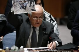 Palestine's Ambassador to the United Nations Riyad Mansour shows pictures of Palestine people as he addresses the Security Council during a meeting about the situation in the Middle East, including Palestine, at United Nations headquarters in New York, July 22, 2014. REUTERS/Eduardo Munoz (UNITED STATES - Tags: POLITICS CIVIL UNREST)