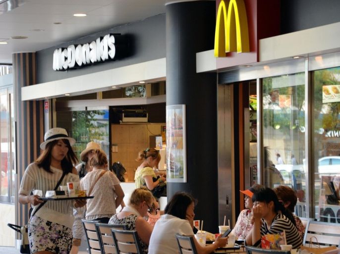 Customers buy their meals at a McDonald's restaurant in Tokyo on July 22, 2014. A scandal involving expired meat sold by a China unit of US food supplier OSI Group spread to Japan on July 22, as McDonald's confirmed that the now shut factory provided Chicken McNuggets to its restaurants. AFP PHOTO / Yoshikazu TSUNO