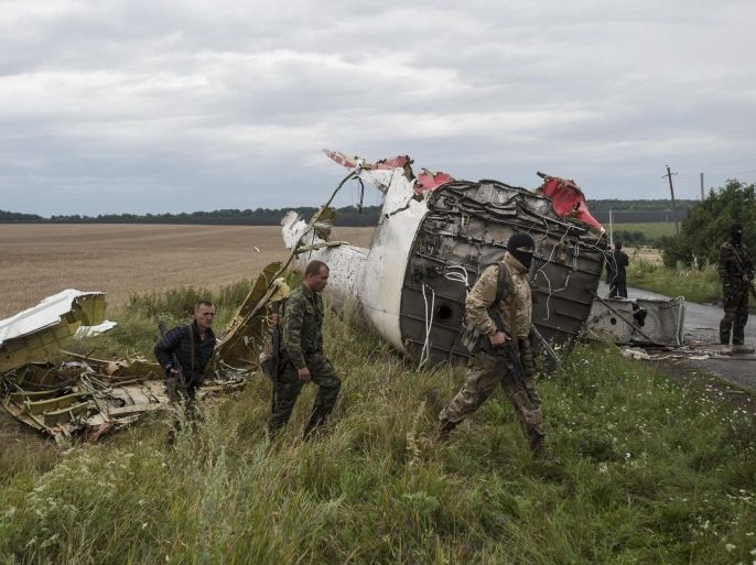 Pro-Russian fighters at the crash site of a Malaysia Airlines passenger jet near the village of Hrabove, Ukraine, Friday, July 18, 2014. Representatives of the OSCE (Organization for Security and Co-operation in Europe) delegation have arrived at the crash site with four Ukrainian experts to begin an investigation into the downing of the Malaysia Airlines plane on Thursday and the deaths of all its passengers and crew. (AP Photo/Evgeniy Maloletka)