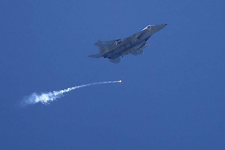 An Israeli F16 jet releases a flare as it files over the Gaza City on, 25 July 2014. A United Nations-run school serving as a shelter for Palestinians displaced by conflict in the Gaza Strip was shelled on 24 July 2014, leaving at least 16 people dead, including women, children and UN staff.