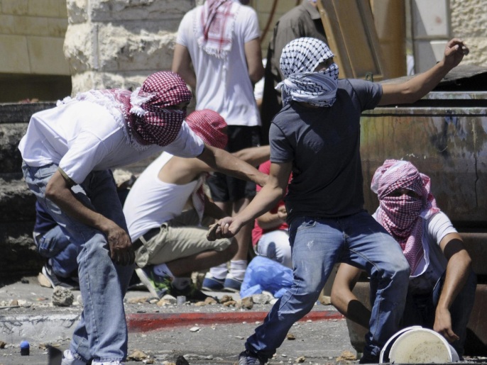 شبان فلسطينيون يرشقون جنود الاحتلال بالحجارة في القدس (أسوشيتد برس)