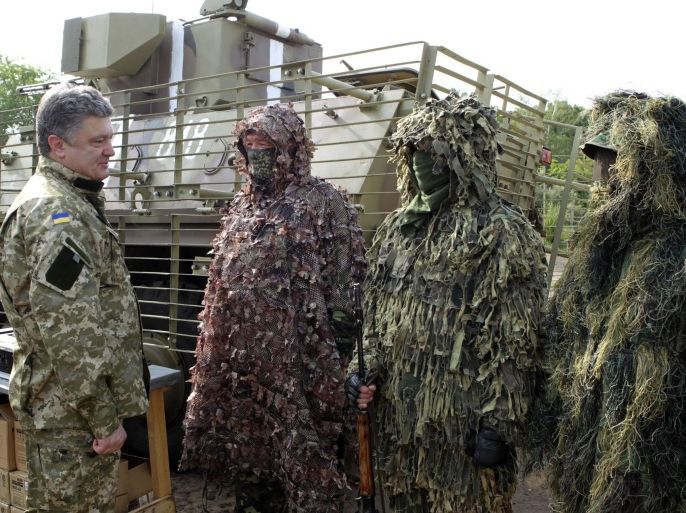 In this photo taken on Friday, June 20, 2014 in Izyum close to Slovyansk, eastern Ukraine Ukrainian President Petro Poroshenko, left, visits troops. Poroshenko in a televised address early Tuesday, July 1, 2014, said he was abandoning a unilateral cease-fire in the conflict with pro-Russian separatists and sending military forces back on the offensive after talks with Russia and European leaders failed to start a broader peace process. The cease-fire expired Monday evening. (AP Photo/Mykhailo Markiv, Pool)