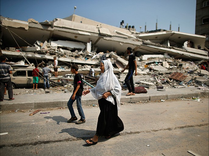 A Palestinian woman walks past the rubble of a residential building, which police said was destroyed in an Israeli air strike, in Gaza City July 22, 2014. Israel kept up its assaults in the Gaza Strip on Tuesday, killing three Palestinians in as many air strikes, as U.S. Secretary of State John Kerry arrived in the region with a mission to seek a ceasefire in the 14-day-old conflict "as soon as possible." The deaths in Khan Younis, Beit Hanoun and Beit Lahiya raised the Palestinian toll to 539 killed, including nearly 100 children and many other civilians, since the offensive was launched on July 8, Gaza health officials said. Israel's death toll also rose to 29, with two soldiers killed in the past day of fighting, the Israeli military said. The total includes two civilians killed by rocket fire.