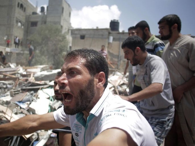 FILE - In this Monday, July 21, 2014, file photo, a Palestinian overcome by emotion watches rescuers carry a body from the rubble of a house which was destroyed by an Israeli missile strike, in Gaza City. Disagreement over whether to lift the Gaza blockade is a key stumbling block to ending more than two weeks of fighting between the Islamic militant Hamas and Israel. Some in Gaza say they would rather endure more fighting than return to life under the blockade. (AP Photo/Khalil Hamra, File)