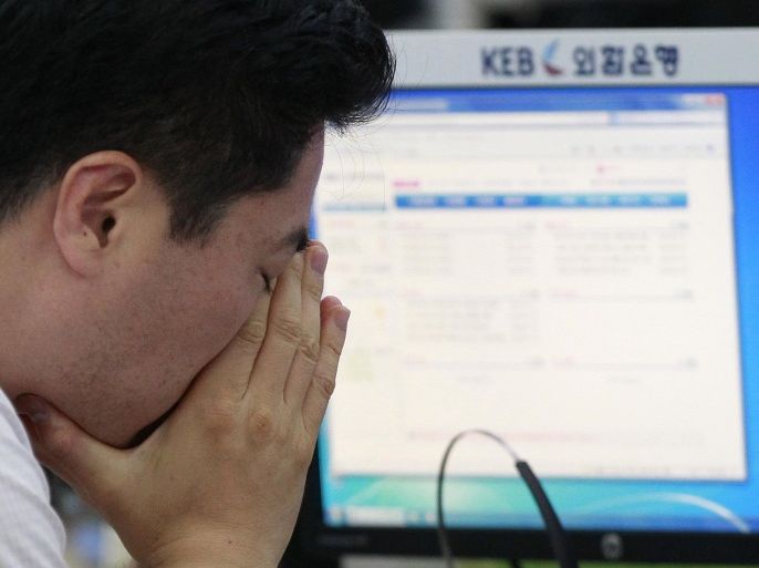 A currency trader reacts as he works at the foreign exchange dealing room of the Korea Exchange Bank headquarters in Seoul, South Korea, Friday, July 11, 2014. Asian stock markets were muted Friday, following the lead of Wall Street traders spooked by worries about the soundness of a bank in Portugal that raised the specter of more financial turmoil in Europe. South Korea's benchmark Kospi dropped 0.70 percent at 1,988.74.( AP Photo/Ahn Young-joon).
