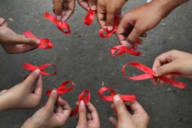 Activists of a non-governmental organization display red ribbons, symbol of HIV-AIDS awareness, as they pose for photographers during an awareness campaign on World AIDS Day, in a business district of Bangalore, India, Sunday, Dec. 1, 2013. UNAIDS lists India as third worst Human Immunodeficiency Virus (HIV) affected country with about 2.5 million infected people after South Africa with 6 million and Nigeria with 2.9 million. (AP Photo/Aijaz Rahi)