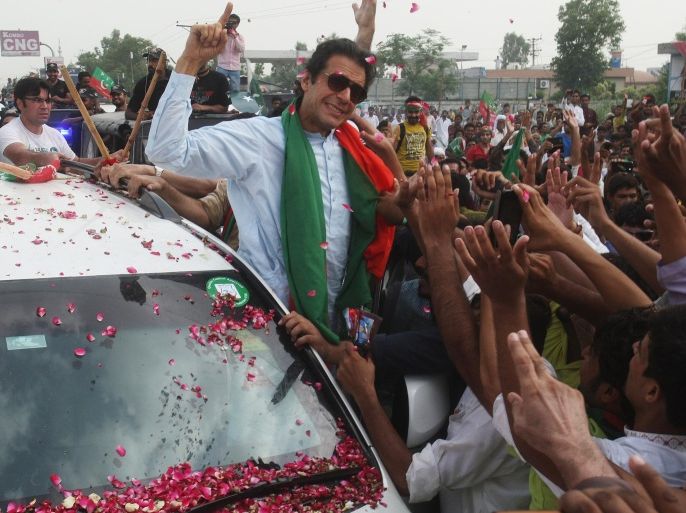 Pakistan's cricketer-turned-politician Imran Khan addresses his supporters Friday, Aug. 15, 2014, in Wazirabad, Pakistan. Supporters of the Pakistani government and opposition protesters clashed on Friday during the second day of a march to the capital, Islamabad, aimed at forcing Prime Minister Nawaz Sharif to resign. (AP Photo/K.M. Chaudary)