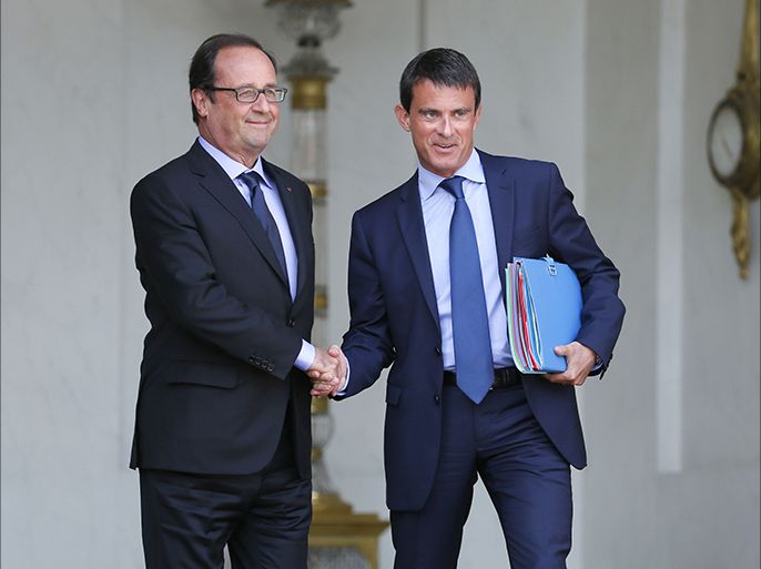 A file picture taken on August 20, 2014 shows French President Francois Hollande (L) and French Prime Minister Manuel Valls shaking hands at the Elysee presidential palace in Paris after a weekly cabinet meeting.