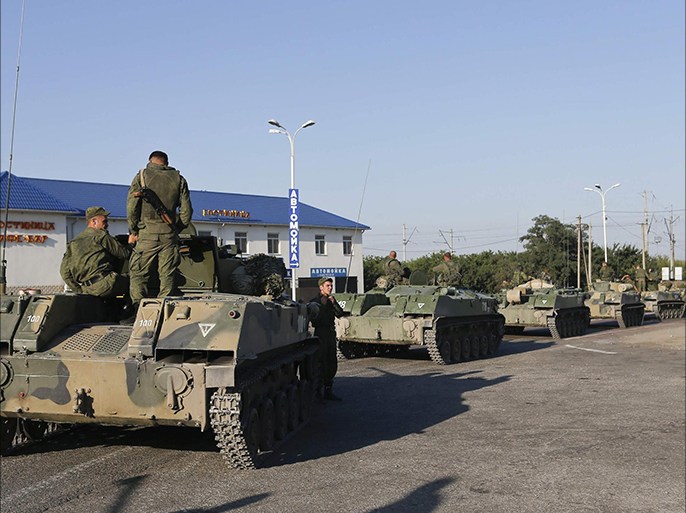 Russian military personnel sit atop armoured vehicles outside Kamensk-Shakhtinsky, Rostov Region, August 15, 2014