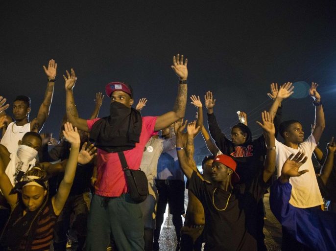 Demonstrators confront police with their arms raised during on-going demonstrations to protest against the shooting of Michael Brown, in Ferguson, Missouri, August 16, 2014. Protesters in Ferguson said late on Friday on Twitter that police had fired tear gas at a crowd protesting over the police shooting death of Brown, an unarmed black teen. The reported outbreak late Friday evening came after almost a week of nighttime clashes between local police and protesters saw a 24-hour break as those police forces were replaced by state police led by an African-American captain. REUTERS/Lucas Jackson (UNITED STATES - Tags: CIVIL UNREST CRIME LAW)
